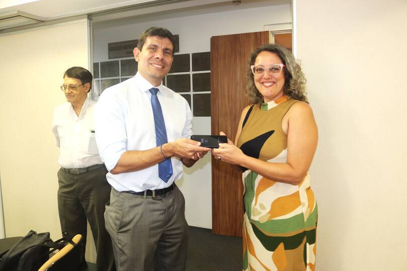 Rafael_Pazos_recebe_o_celular_corporativo_das_mãos_de_Daniela_Muller_como_símbolo_de_passagem.jpg